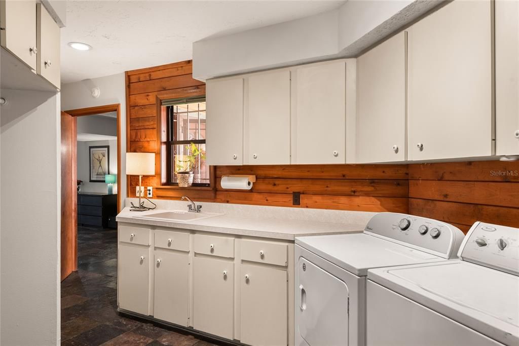 The spacious laundry room offers plenty of counter space and storage for all your laundry needs.