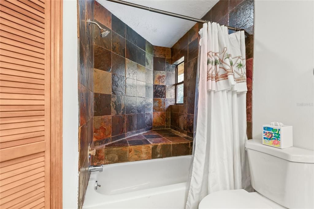 A closer look at the upstairs bathroom highlights the unique tilework in the shower.