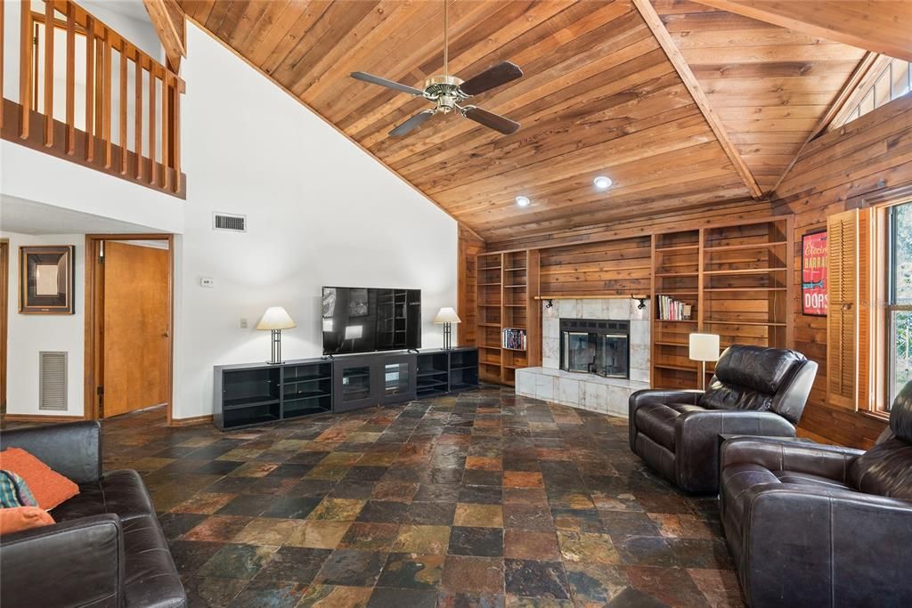 Another view of the family room showcasing the wood-burning fireplace and ample space for seating.