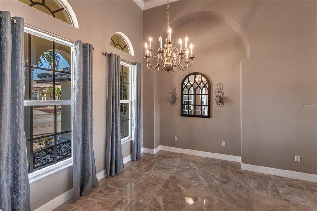 High ceilings, natural light, and coffered details create a formal dining space.