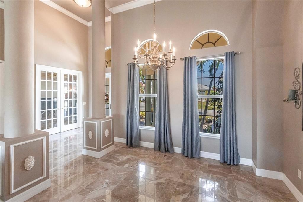 High ceilings, natural light, and coffered details create a formal dining space.