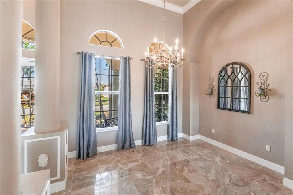 High ceilings, natural light, and coffered details create a formal dining space.