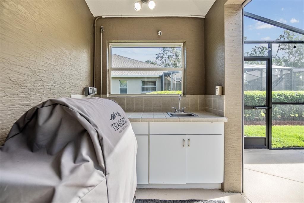 Outdoor sink area w/ window under covered patio