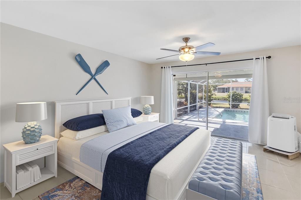 VIRTUALLY STAGED PRIMARY BEDROOM WITH SLIDER DOORS TO THE POOL