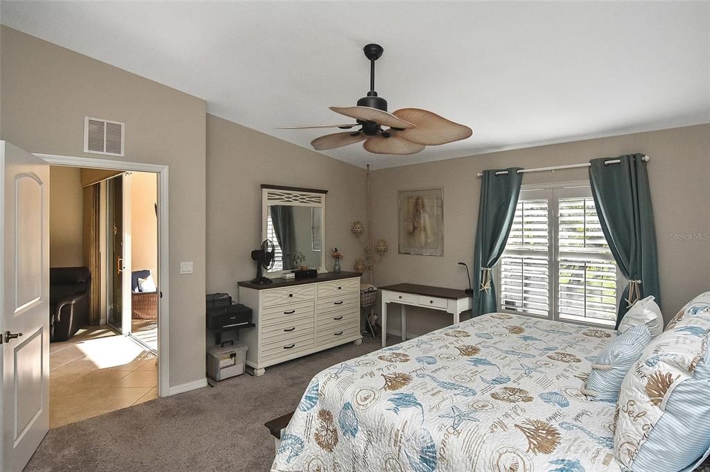 Primary Bedroom looks out to screened Lanai