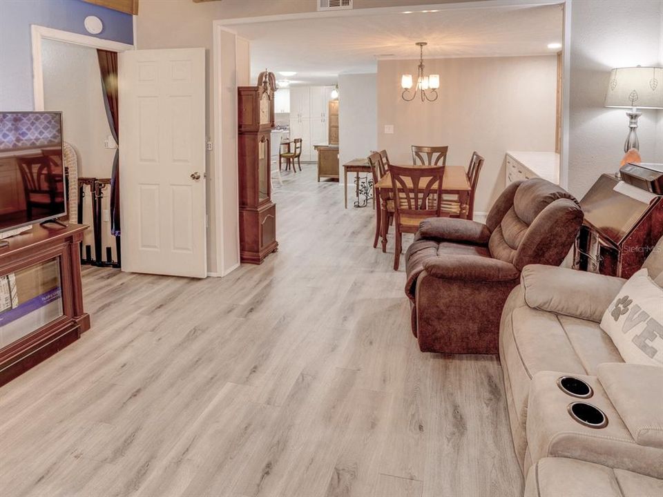 Living room with view of the dining room and bedroom to the left.