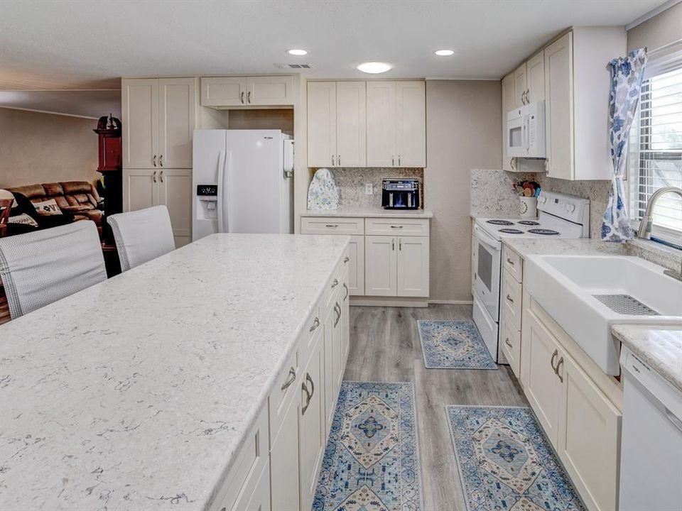 Kitchen with antique white shaker cabinets and a solid surface Cortez countertop.