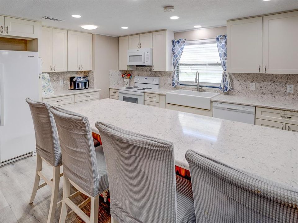 Kitchen with antique white shaker cabinets and a solid surface Cortez countertop.