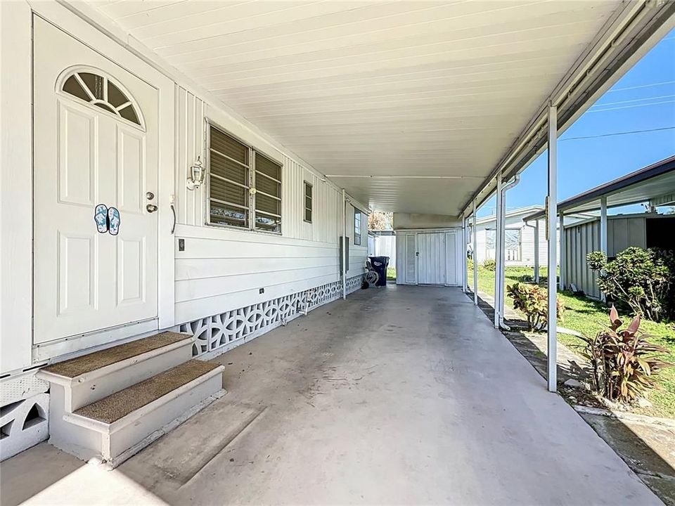 Carport with two sheds a the end.