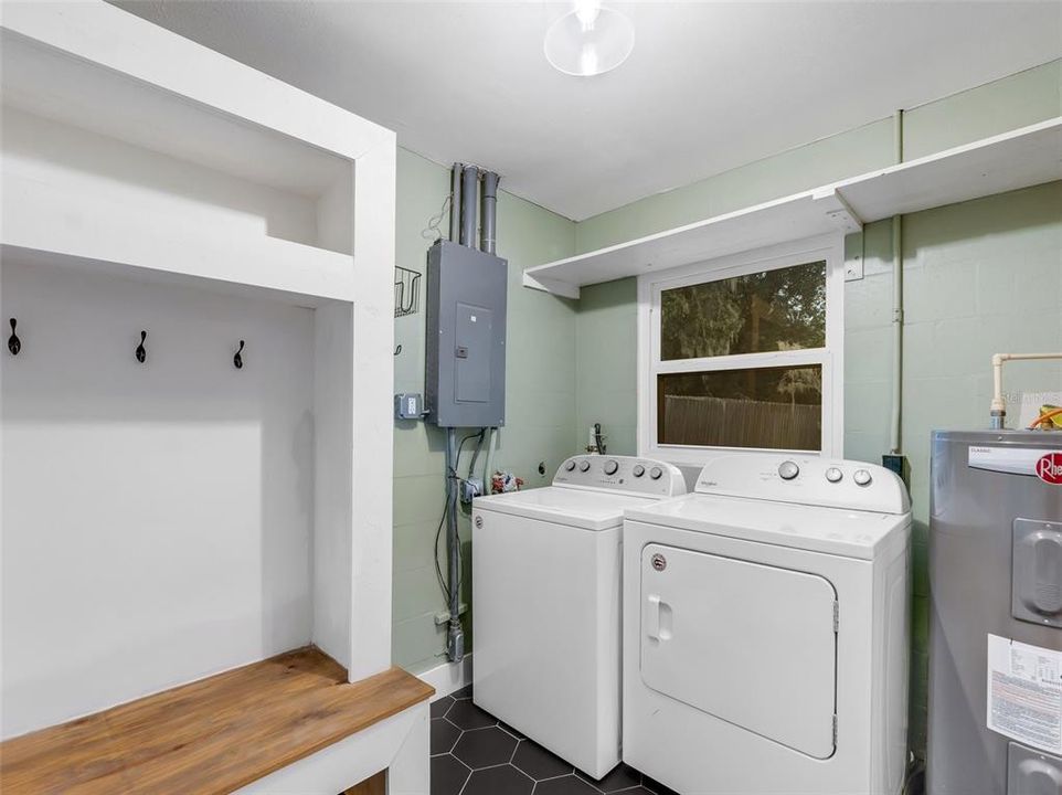 The indoor laundry room with built-in storage and the washer & Dryer convey with the sale.