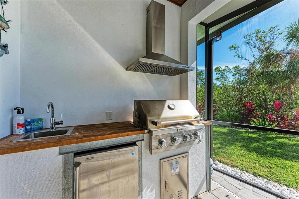 Pool area with grill, fridge and sink