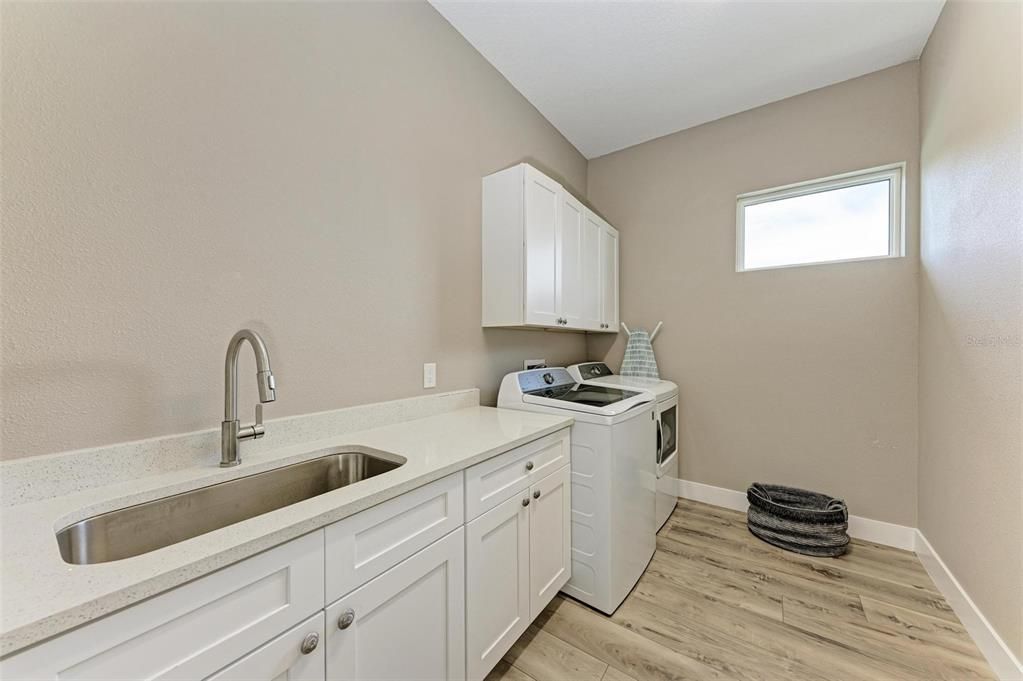 1st floor laundry room with utility sink and cabinets