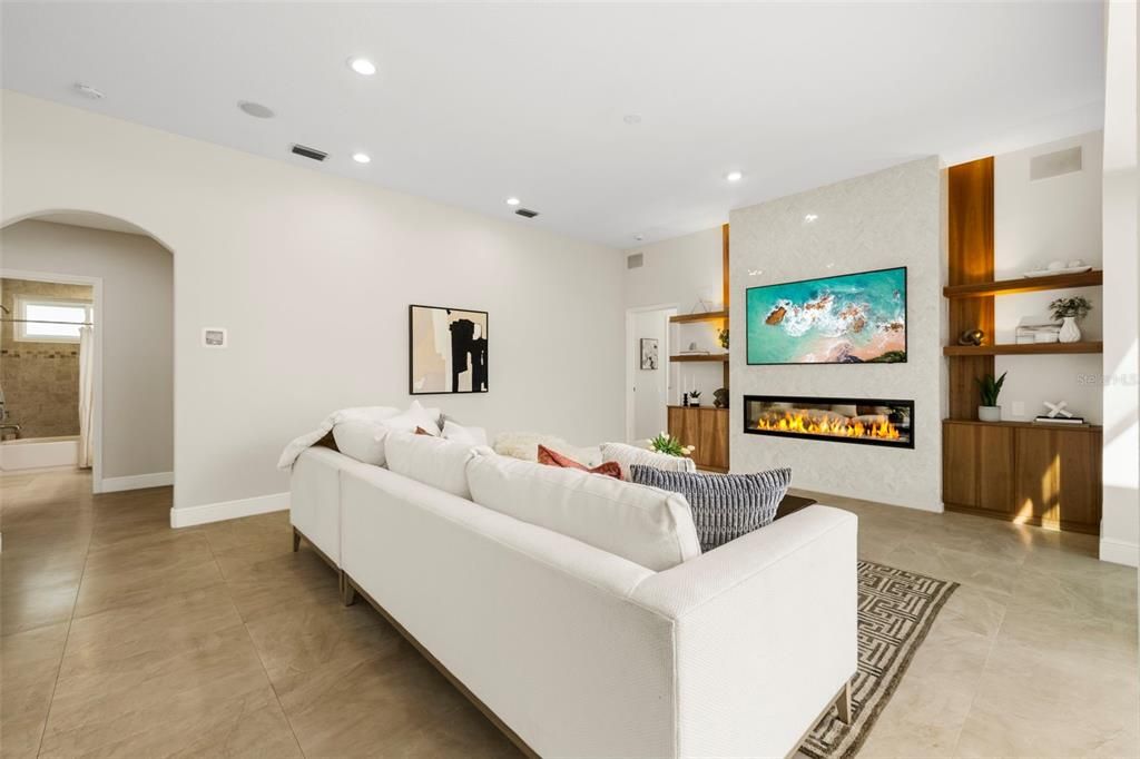 Living area with custom fireplace and built in shelving.