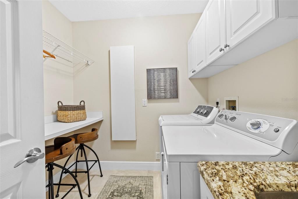 Laundry with workspace and built in ironing board.