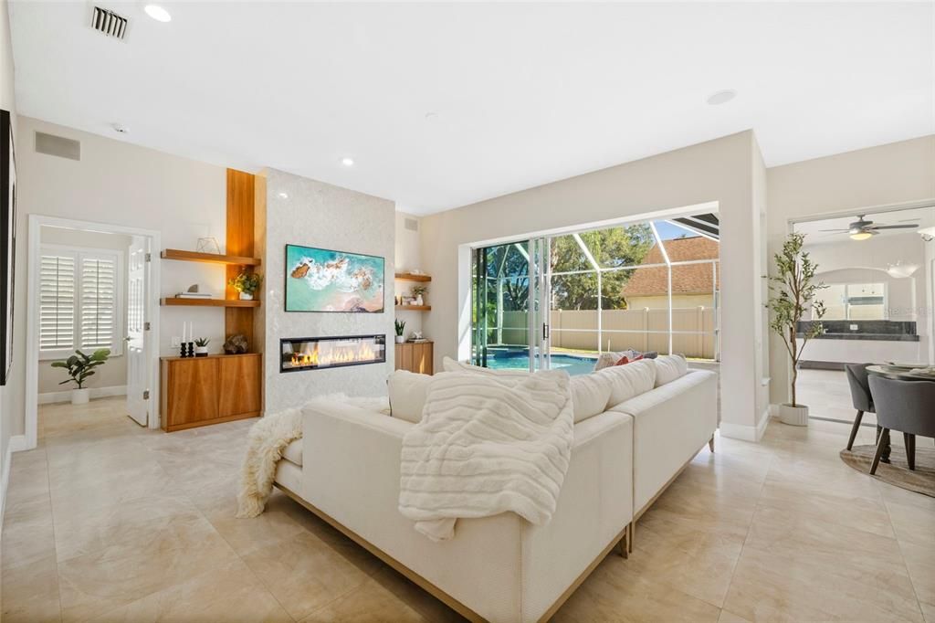 Living area with custom fireplace and built in shelving.