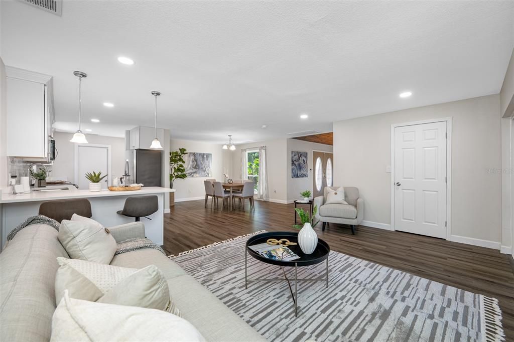 View of entry foyer, dining room, and kitchen taken from the family room.  The door pictured on the right leads to a walk-in closet conveniently located in close proximity to the kitchen