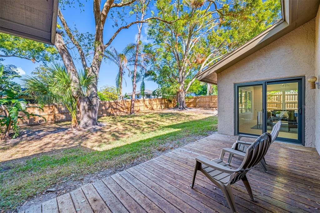 View of fenced rear yard taken from rear wood deck