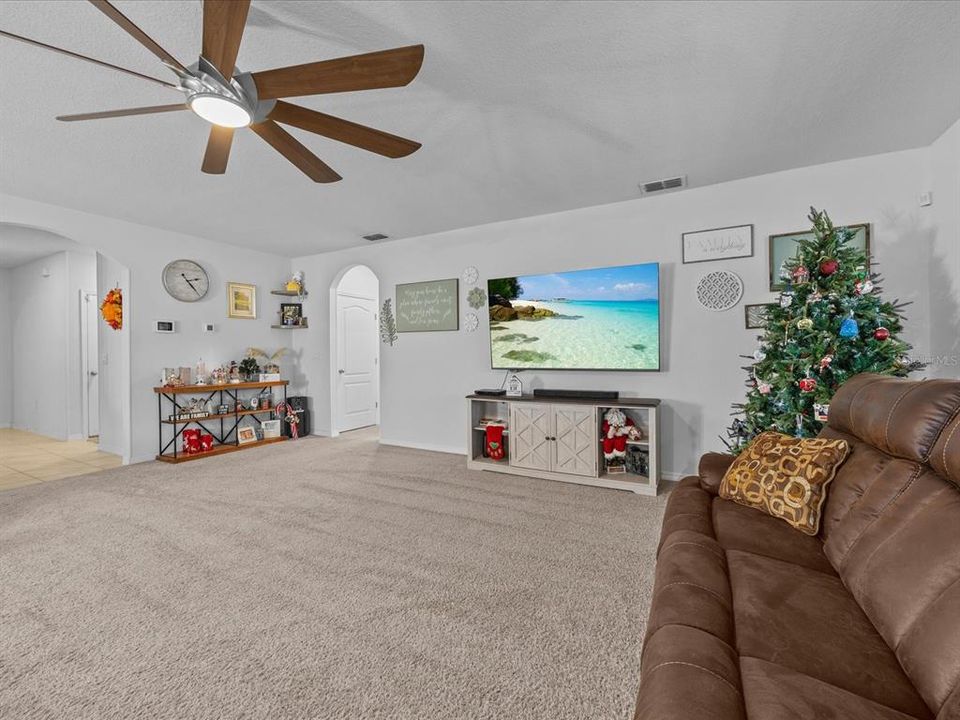 Living room with hall ways accessing the primary bedroom and entryway