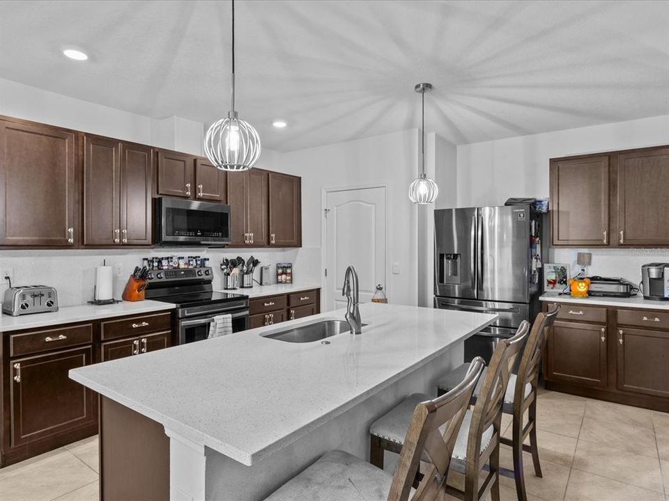 Kitchen with granite countertops, solid wood cabinets and decorative light fixtures