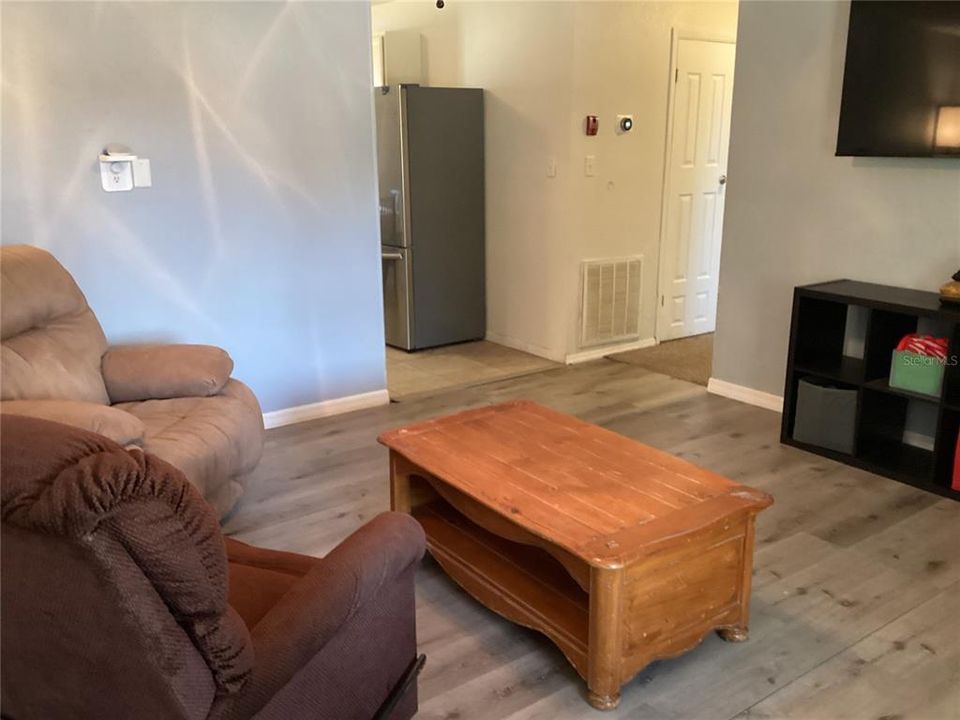 To the left is the kitchen. To the right is the hallway with two closets.