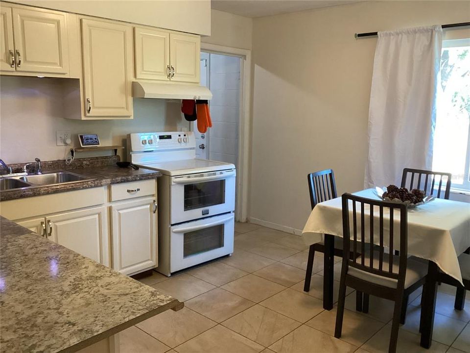 Happy and sunny kitchen with newly-painted walls and cabinets and new hardware.