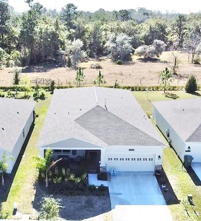 Front of home showing wooded area behind