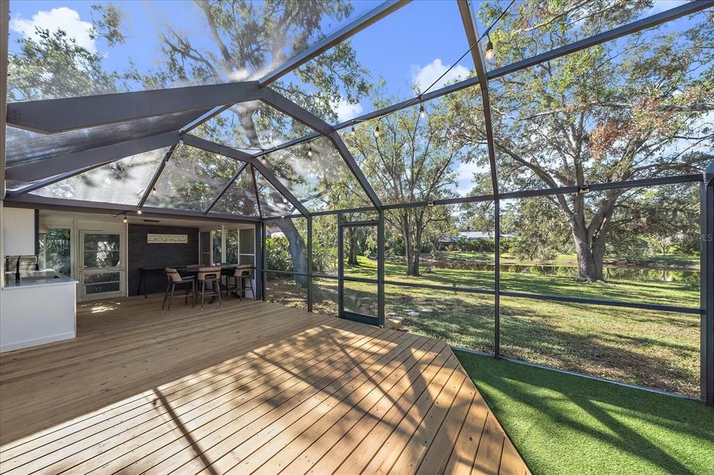 Screened in back patio with turf