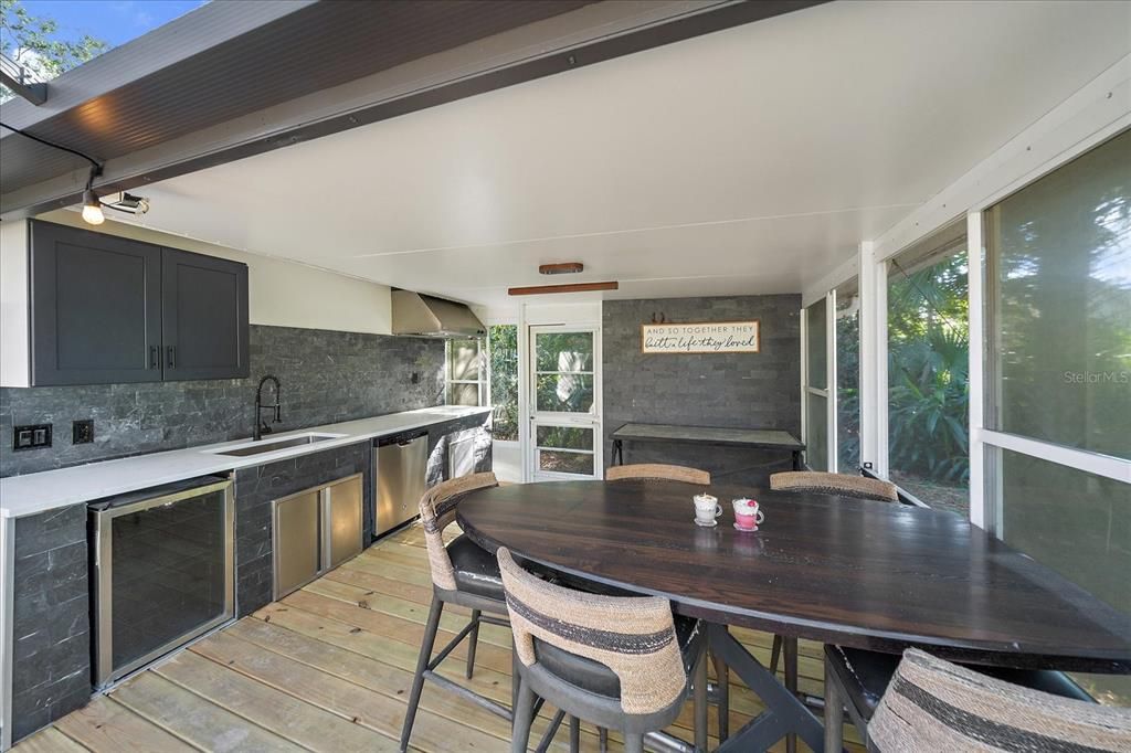 Outdoor Kitchen: Bar fridge, sink, dishwasher and range hood