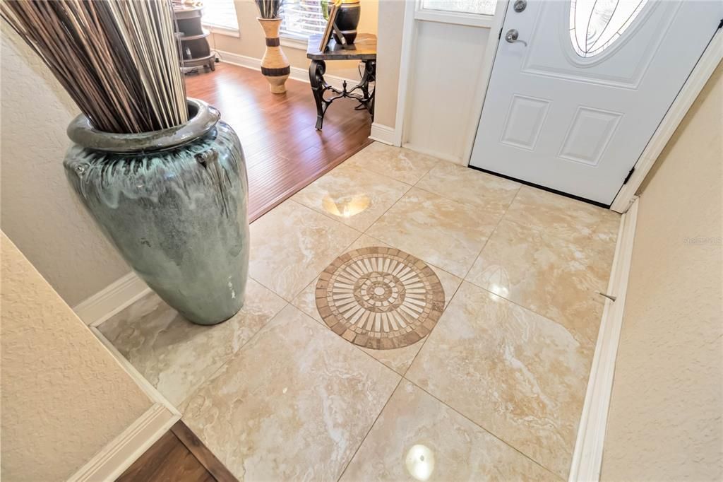 Foyer with decorative mosaic tile inlay.