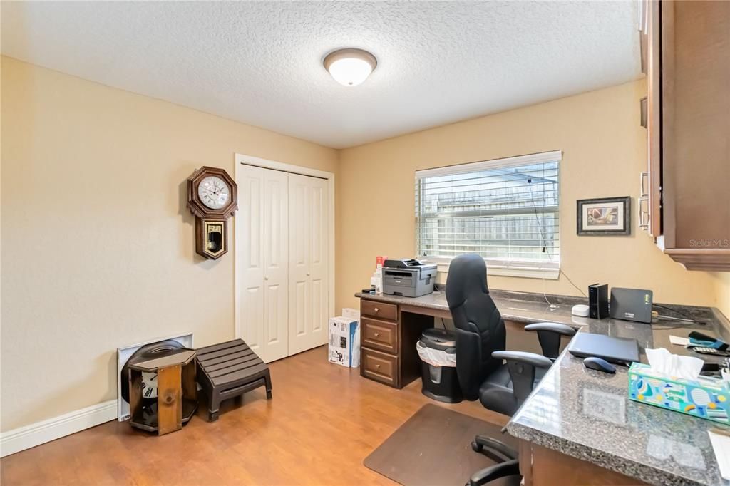 Guest bedroom currently used as an office with built in desk and cabinets.