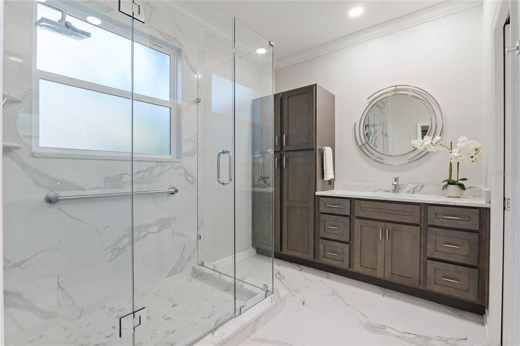 10' x 11' Remodeled Primary Bathroom w/ flameless glass enclosed shower, grab bar & separate granite vanities