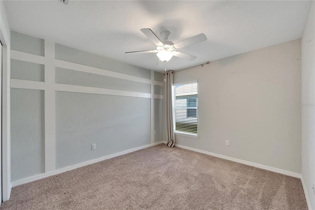 Secondary bedroom with accent wall