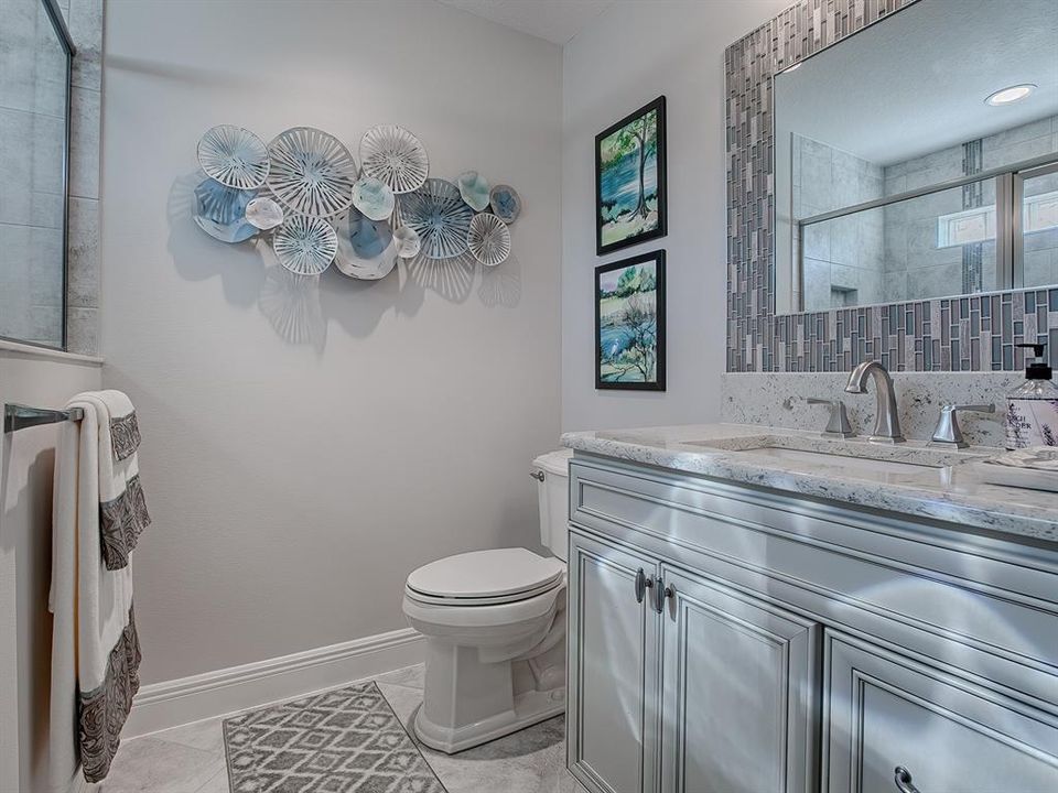 FULL BATH WITH QUARTZ COUNTERTOPS AND CUSTOM MIRROR.