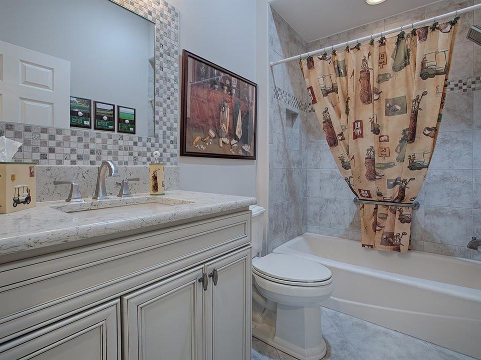 2ND GUEST BATH WITH QUARTZ COUNTERTOP, CUSTOM MIRROR AND TUB/SHOWER.