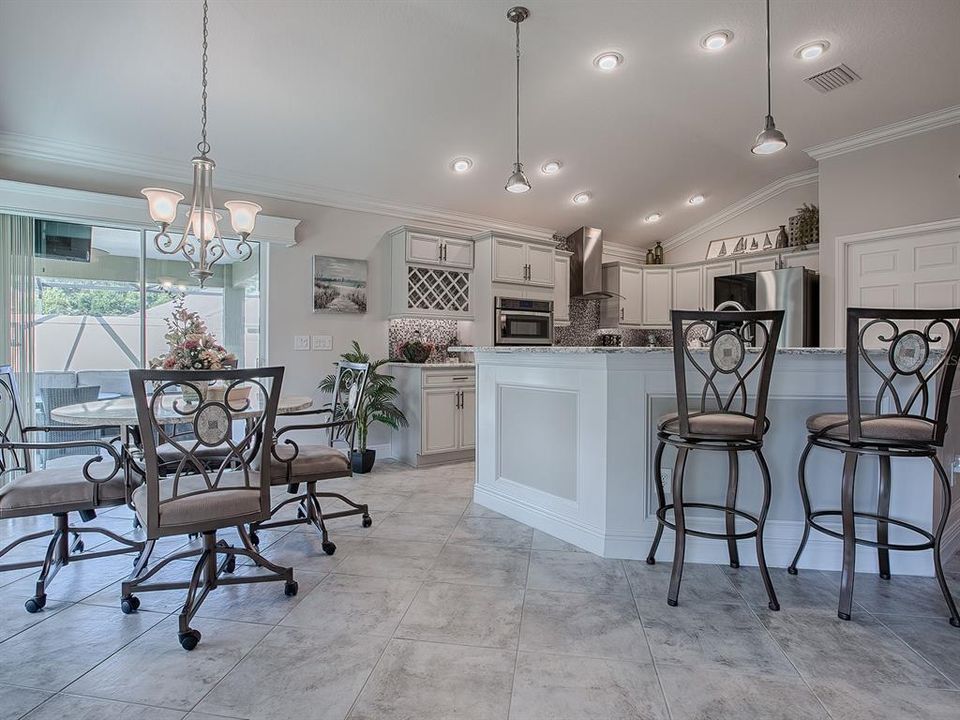 CONVENIENT BREAKFAST BAR WITH PENDANT LIGHTING.