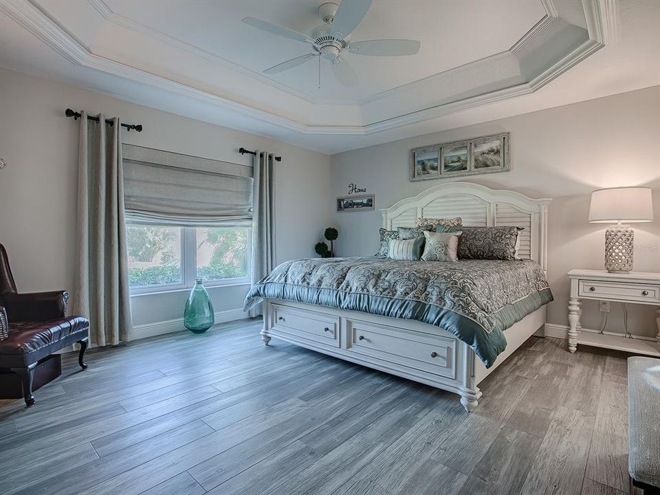 EXTENDED FRONT GUEST ROOM WITH LUXURY VINYL PLANK FLOORING, CROWN TRIMMED TRAY CEILING, AND AN EN-SUITE BATH.