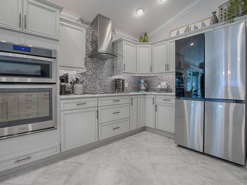 WALL OVEN WITH CONVECTION/MICROWAVE ABOVE. ELECTRIC COOKTOP WITH RANGE HOOD. LOVELY MOSAIC TILE BACKSPLASH AND UNDER CABINET LIGHTING.