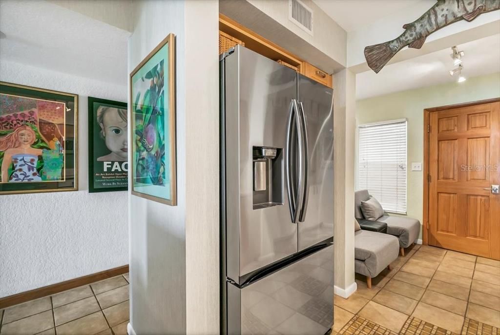 View from kitchen to entry foyer on left and breakfast nook (currently used as a den) on the right. Door on right is the laundry room.