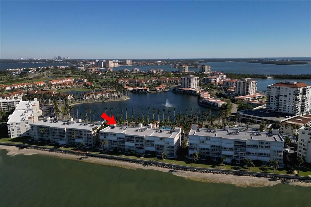 Aerial view to east. Red arrow points to the building (NOT the unit). Lake Bahia, the Isla del Sol golf course, and downtown St Petersburg are in the background.