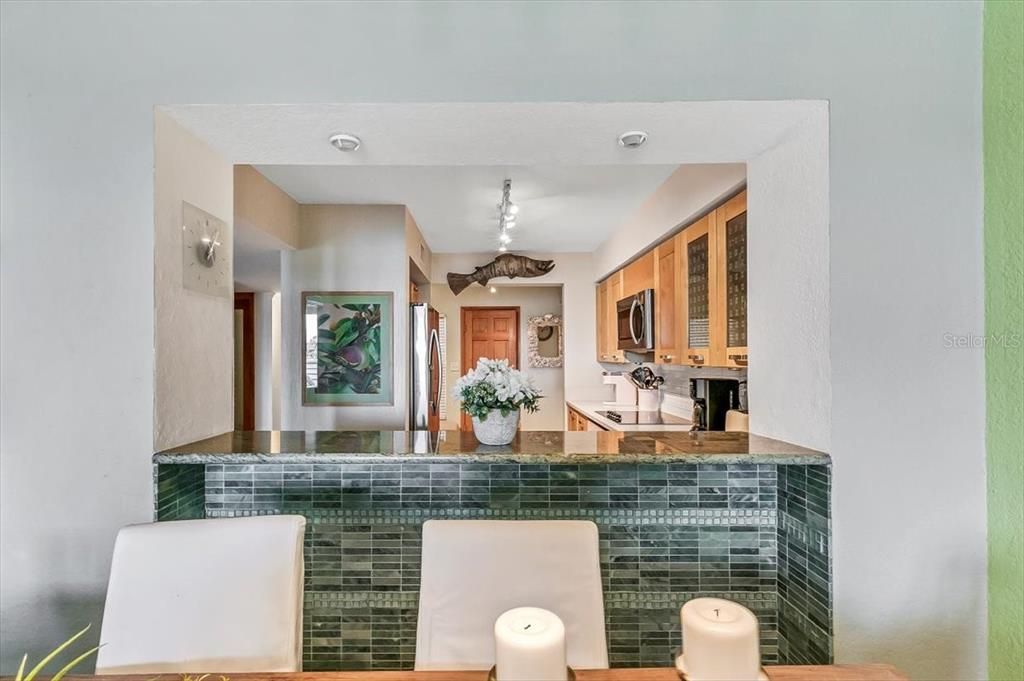 View from dining area to kitchen with laundry room door in background.