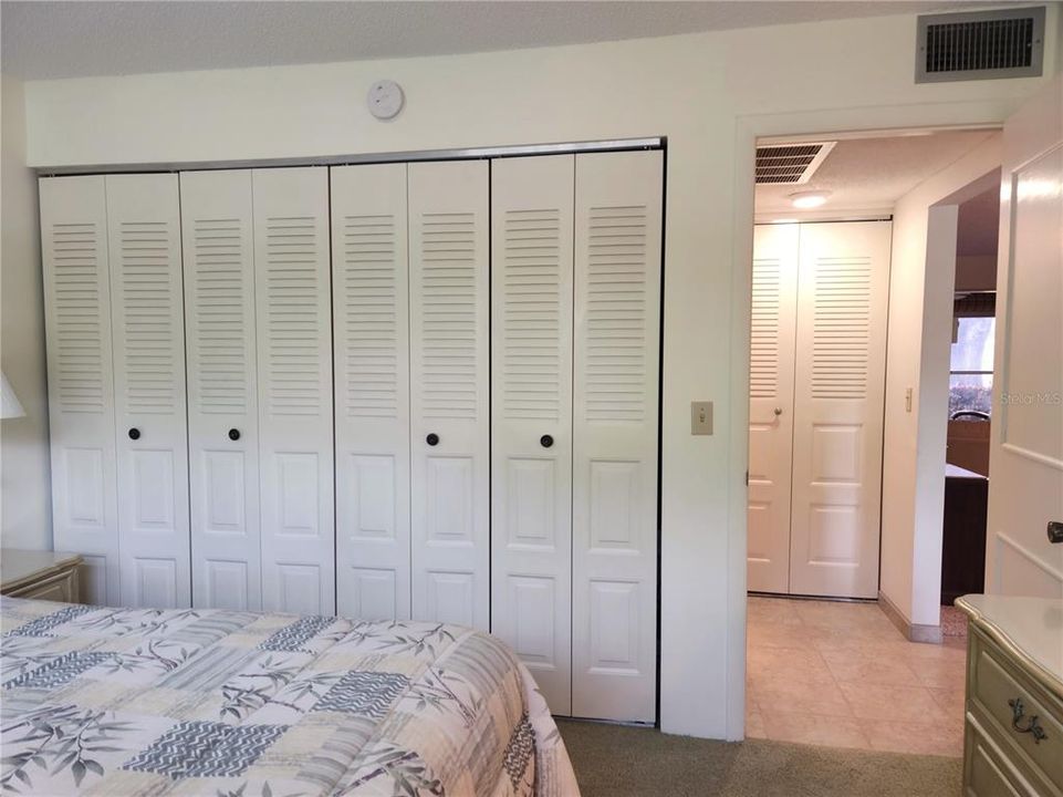 Guest bedroom view of closet and entry to hallway. Guest bathroom on left. Laundry closet straight ahead. Living area to right of hallway entry.