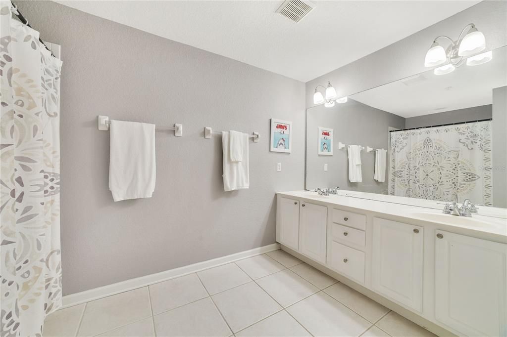 Large primary bathroom with double sinks and stone counters.