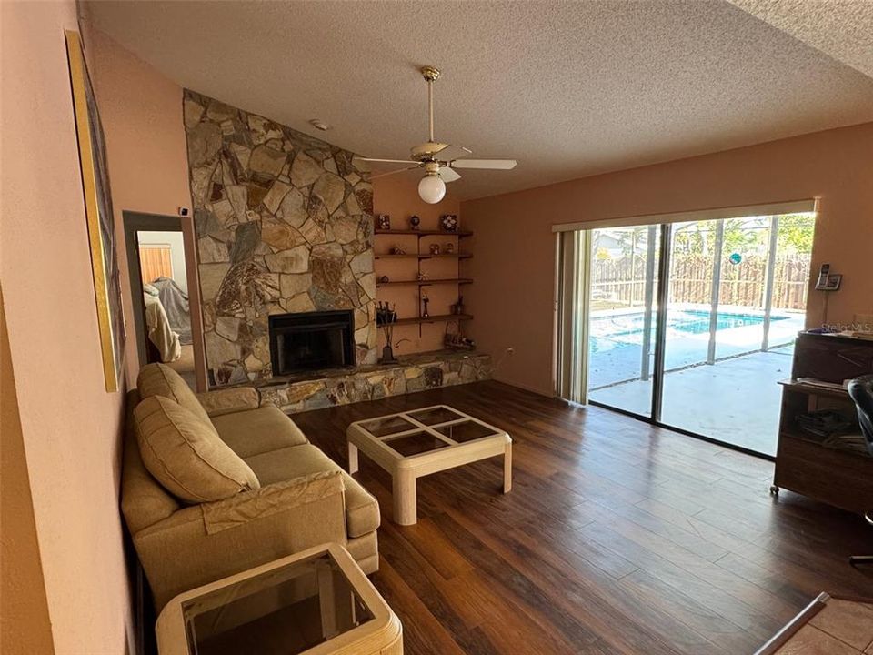 Family Room with a Vaulted Ceiling and a Stone Woodburning Fireplace