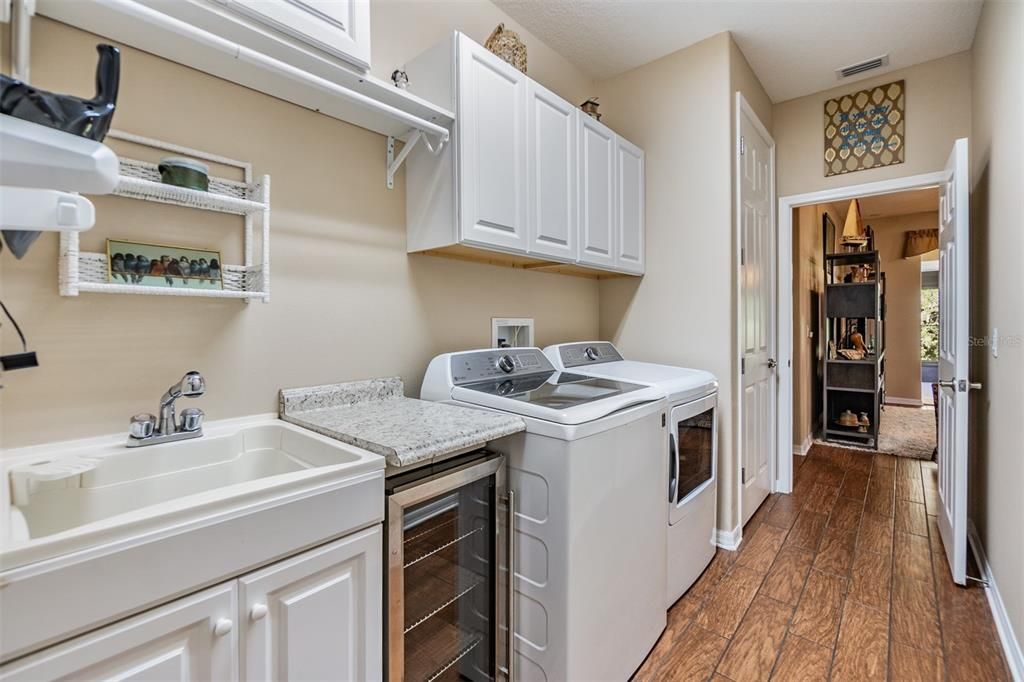 Built in utility sink and wine cooler in this functional laundry room