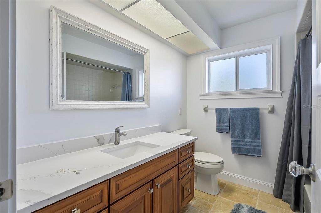 Guest bathroom with custom cabinets, under-mount sink and custom travertine flooring