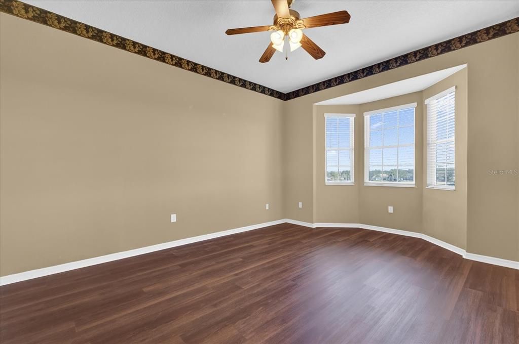 RIMARY BEDROOM WITH RICH WOOD FLOORS