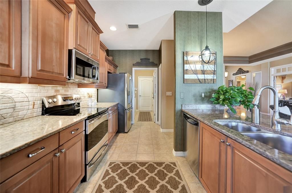 Kitchen with streamlined layout walking back through laundry room and on to garage door