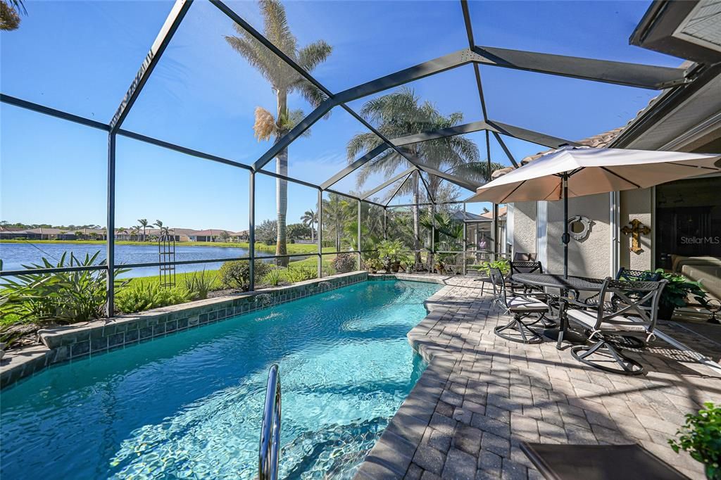 Well manicured pool with 2 sheer descent fountains and lanai pictured off to right