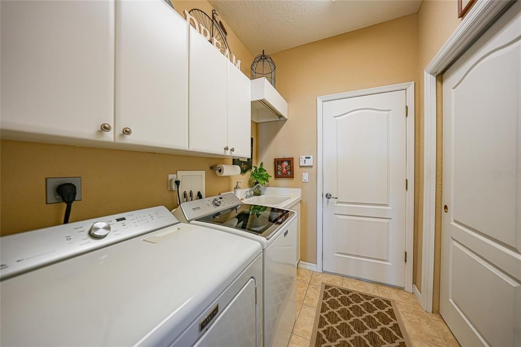 Laundry room with sink, more storage & garage door