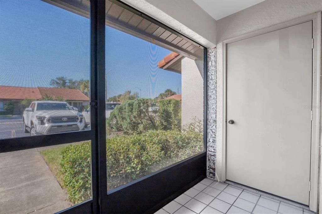 The front entry porch looking out. Your assigned parking space is front of your door and there are guest spots around for friends and family to stop by. The door is a nice storage closet. Extra space!